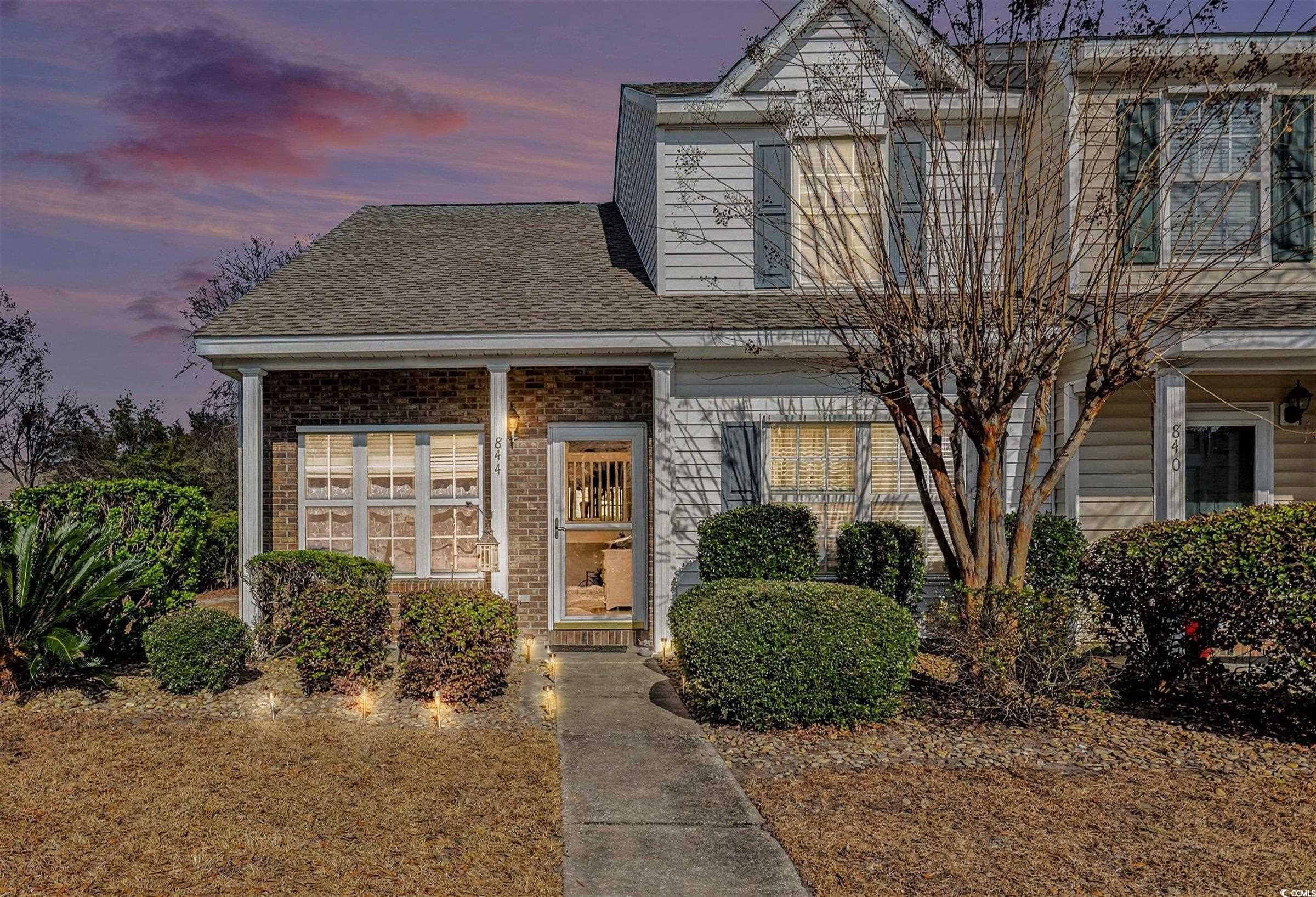 Traditional-style home featuring a shingled roof and brick siding