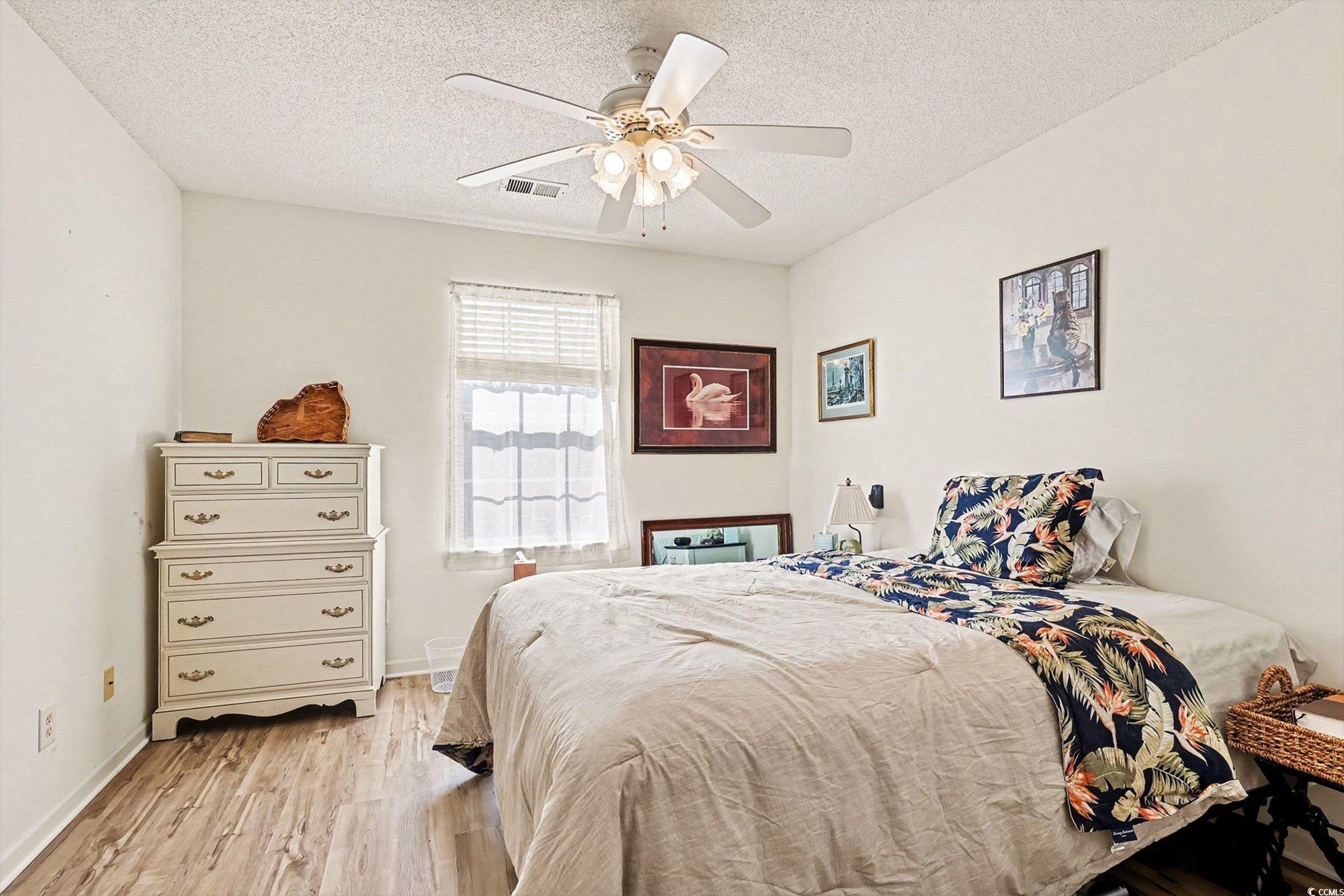 844 Sheridan Road, Unit 844 Myrtle Beach, SC 29579 - Photo 12 of 24 Bedroom with light wood-style flooring, a textured ceiling, and a ceiling fan
