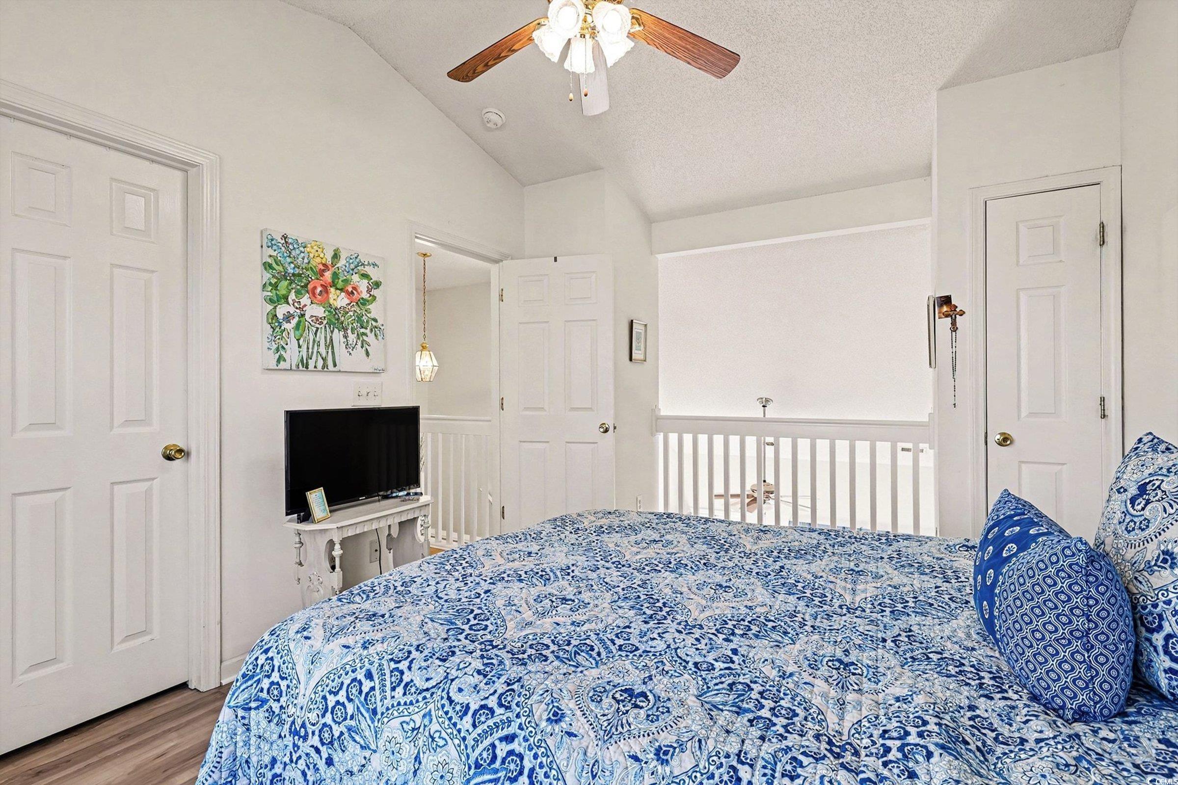 844 Sheridan Road, Unit 844 Myrtle Beach, SC 29579 - Photo 14 of 24 Bedroom with vaulted ceiling, wood finished floors, a textured ceiling, and ceiling fan
