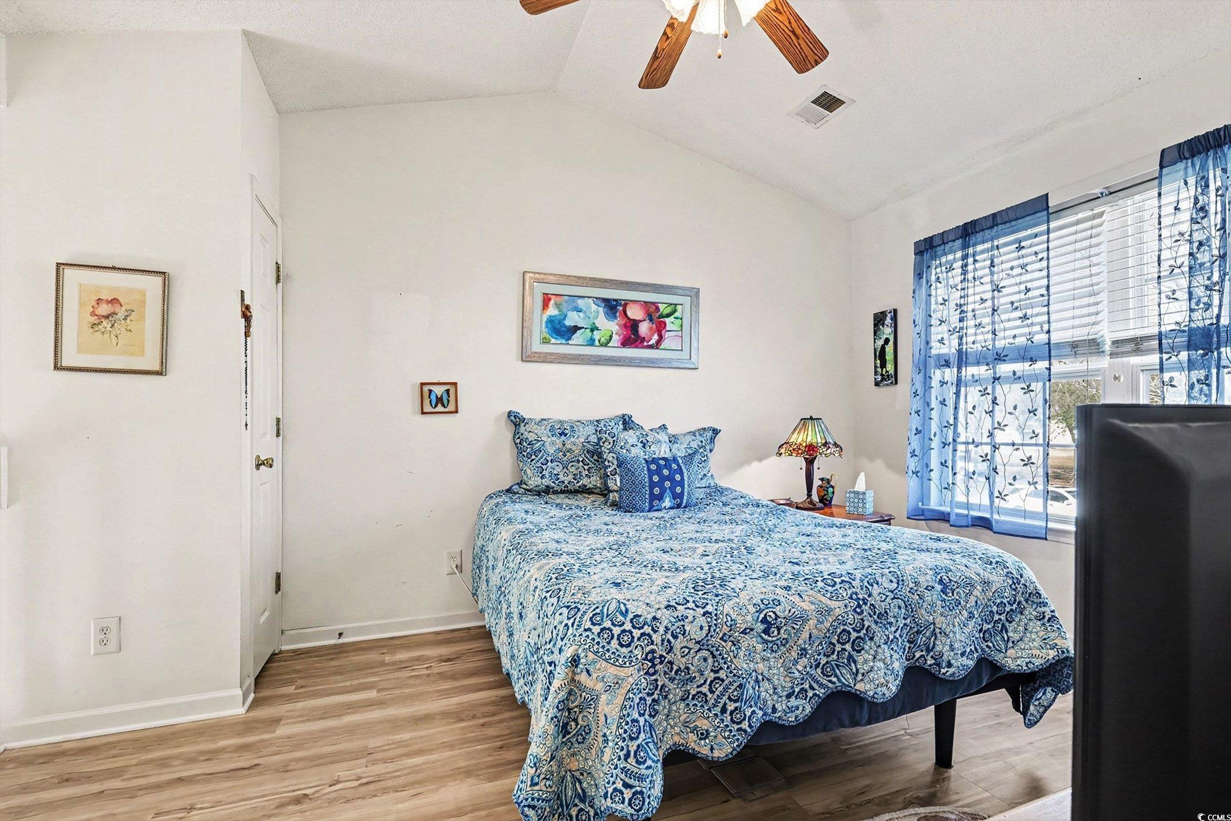 844 Sheridan Road, Unit 844 Myrtle Beach, SC 29579 - Photo 5 of 24 Bedroom featuring vaulted ceiling, light wood-style flooring, and a ceiling fan