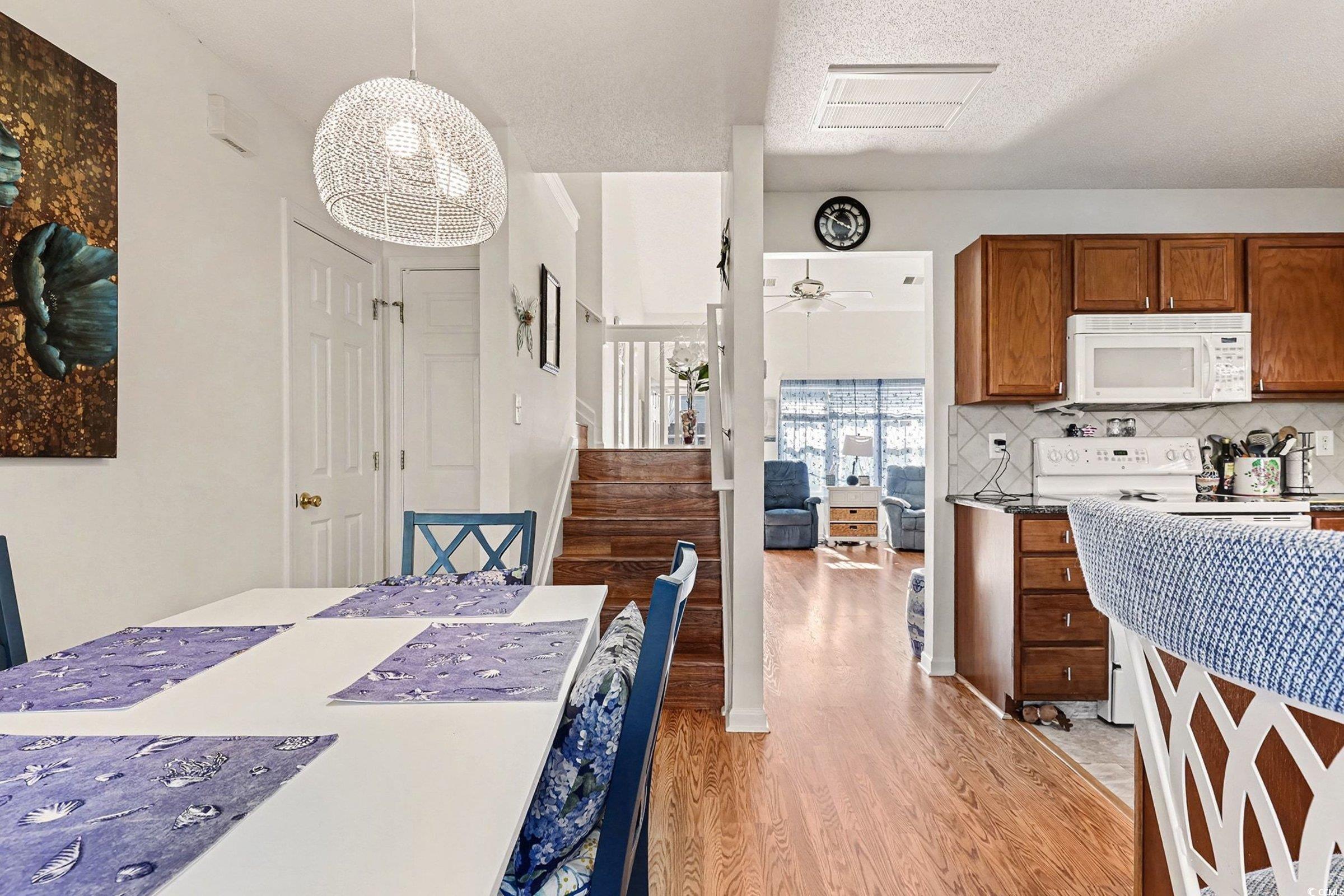 844 Sheridan Road, Unit 844 Myrtle Beach, SC 29579 - Photo 9 of 24 Dining room with stairway, light wood-type flooring, a textured ceiling, a ceiling fan, and a chandelier