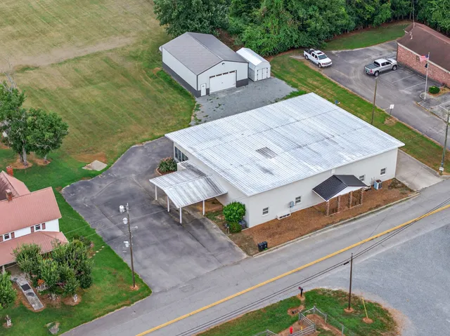 a view of a livingroom with furniture wooden floor ceiling fan and windows