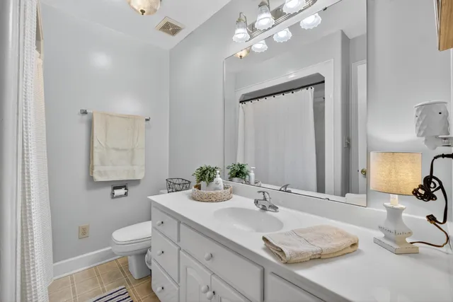 a bathroom with a sink a toilet and mirror