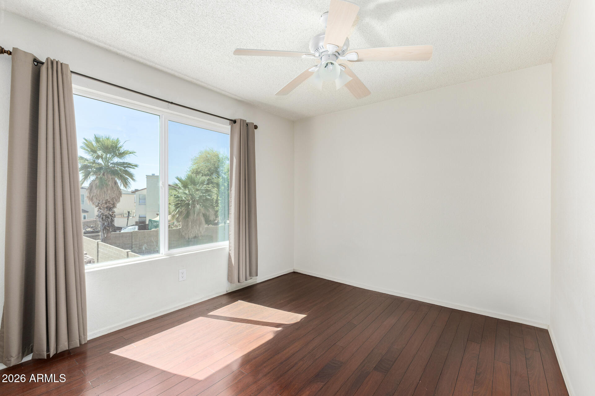 4741 West Marco Polo Road Glendale, AZ 85308 - Photo 19 of 32 an empty room with wooden floor and windows