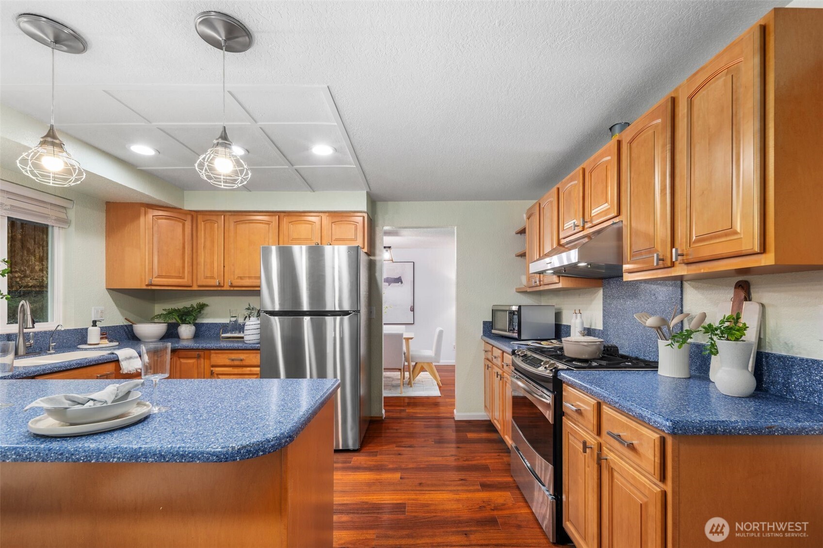 18016 Southeast 147th Street Renton, WA 98059 - Photo 7 of 38 a kitchen with stainless steel appliances granite countertop a sink refrigerator and cabinets