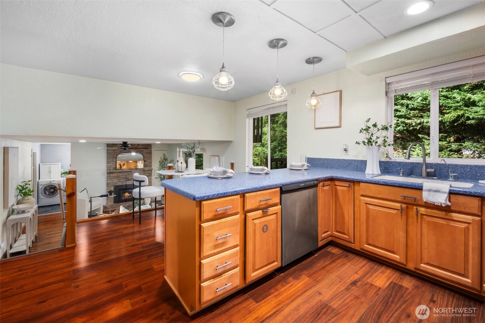 18016 Southeast 147th Street Renton, WA 98059 - Photo 8 of 38 a kitchen with stainless steel appliances granite countertop a stove a sink dishwasher and a flat tv with wooden floor