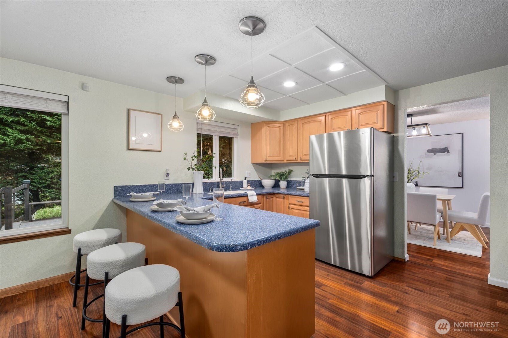 18016 Southeast 147th Street Renton, WA 98059 - Photo 9 of 38 a kitchen with stainless steel appliances granite countertop a refrigerator a stove a sink dishwasher a dining table and chairs with wooden floor