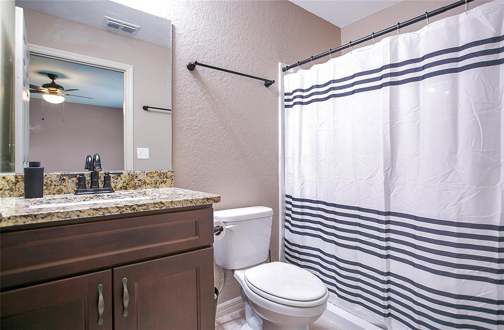 6949 Southwest 152nd Street Ocala, FL 34473 - Photo 11 of 20 a bathroom with a granite countertop sink a toilet and a mirror