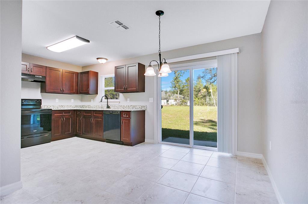 6949 Southwest 152nd Street Ocala, FL 34473 - Photo 6 of 20 a kitchen with kitchen island a counter top a stove a sink and a refrigerator