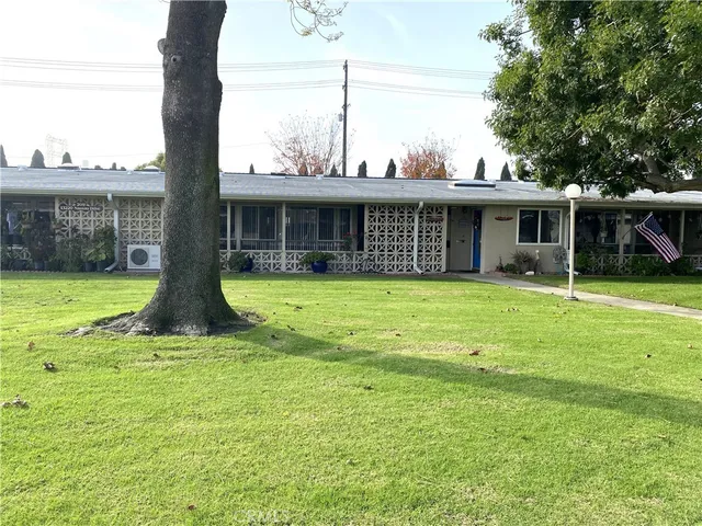a view of a house with yard and sitting area