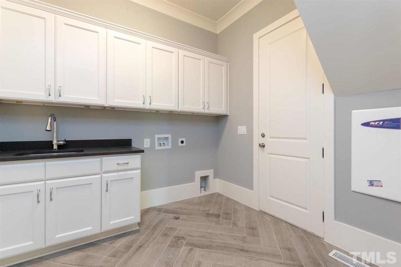 5000 Fanyon Way Raleigh, NC 27612 - Photo 12 of 25 Laundry room with full wall cabinets, sink with granite countertops, built in bench with cubbies for storage!