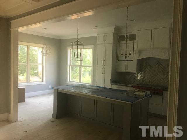 5000 Fanyon Way Raleigh, NC 27612 - Photo 14 of 25 All the extras including oversized island with quartz/granite countertops,seating for 5, custom pendant lighting, white stacked cabinets plus spacious breakfast nook area overlooking scenic backyard.
