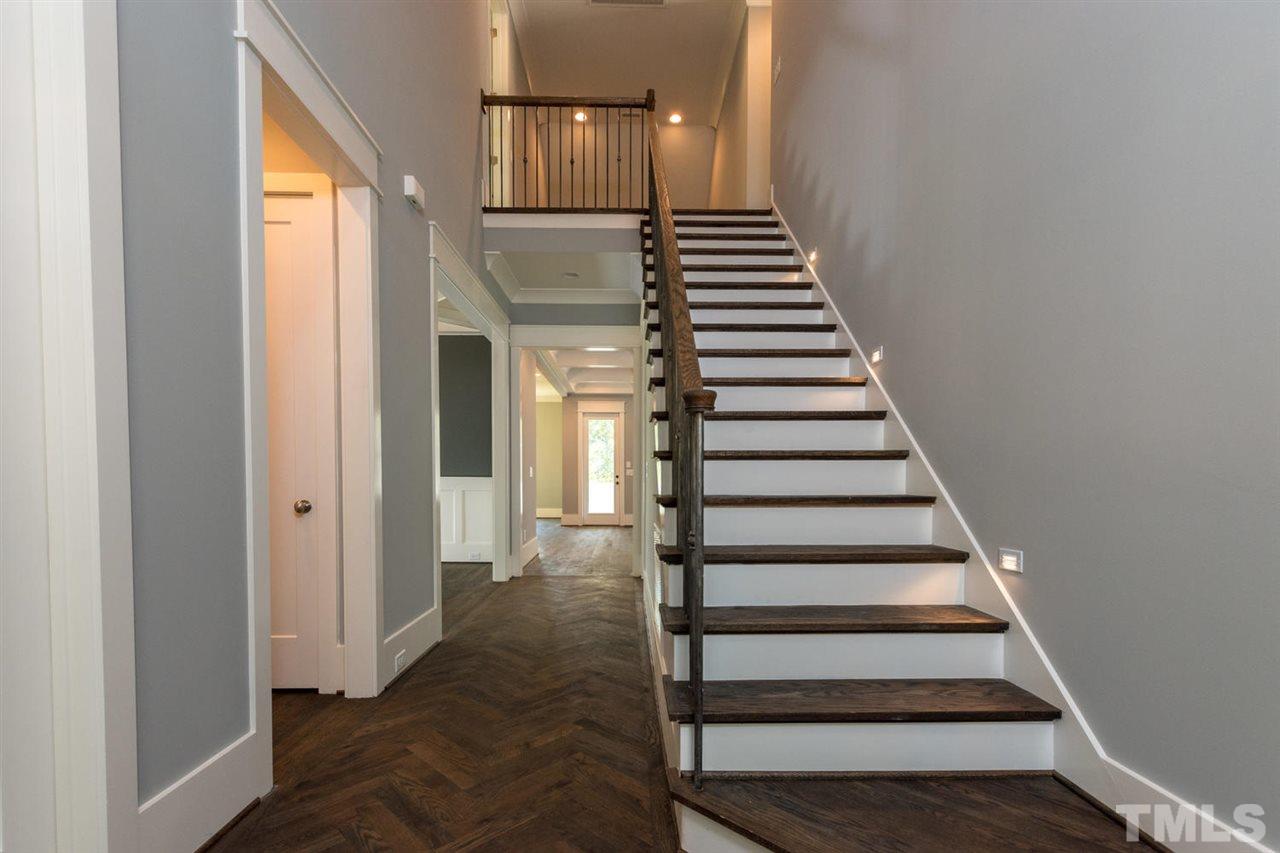 5000 Fanyon Way Raleigh, NC 27612 - Photo 3 of 25 Hardwood floors in herringbone pattern. Hardwood treads on stairs with wrought iron picket railings.Oak noel posts.