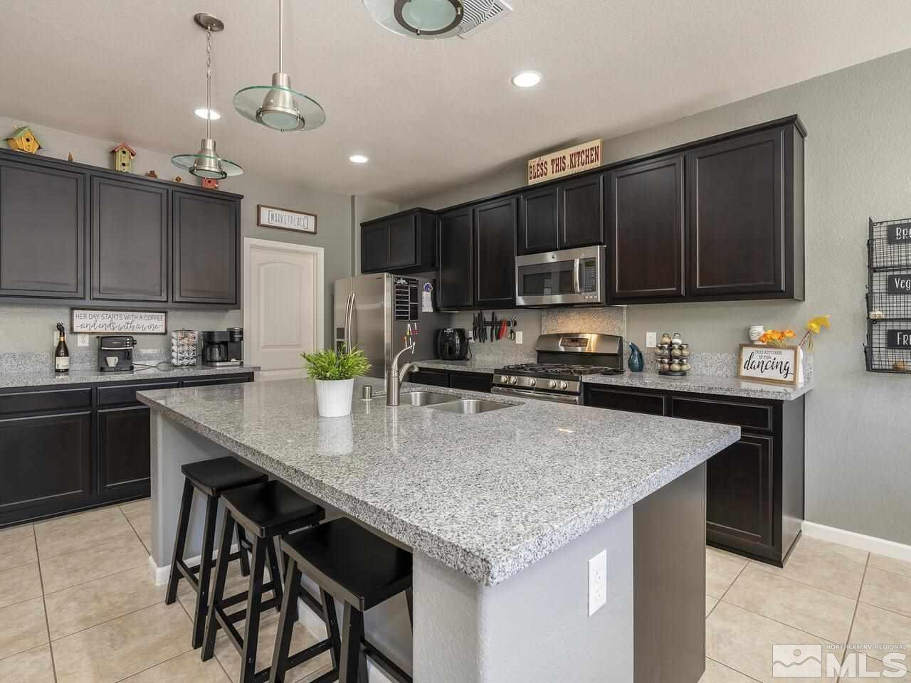 2090 Tawleed Road Reno, NV 89521 - Photo 9 of 24 a kitchen with kitchen island granite countertop stainless steel appliances cabinets a sink and a counter