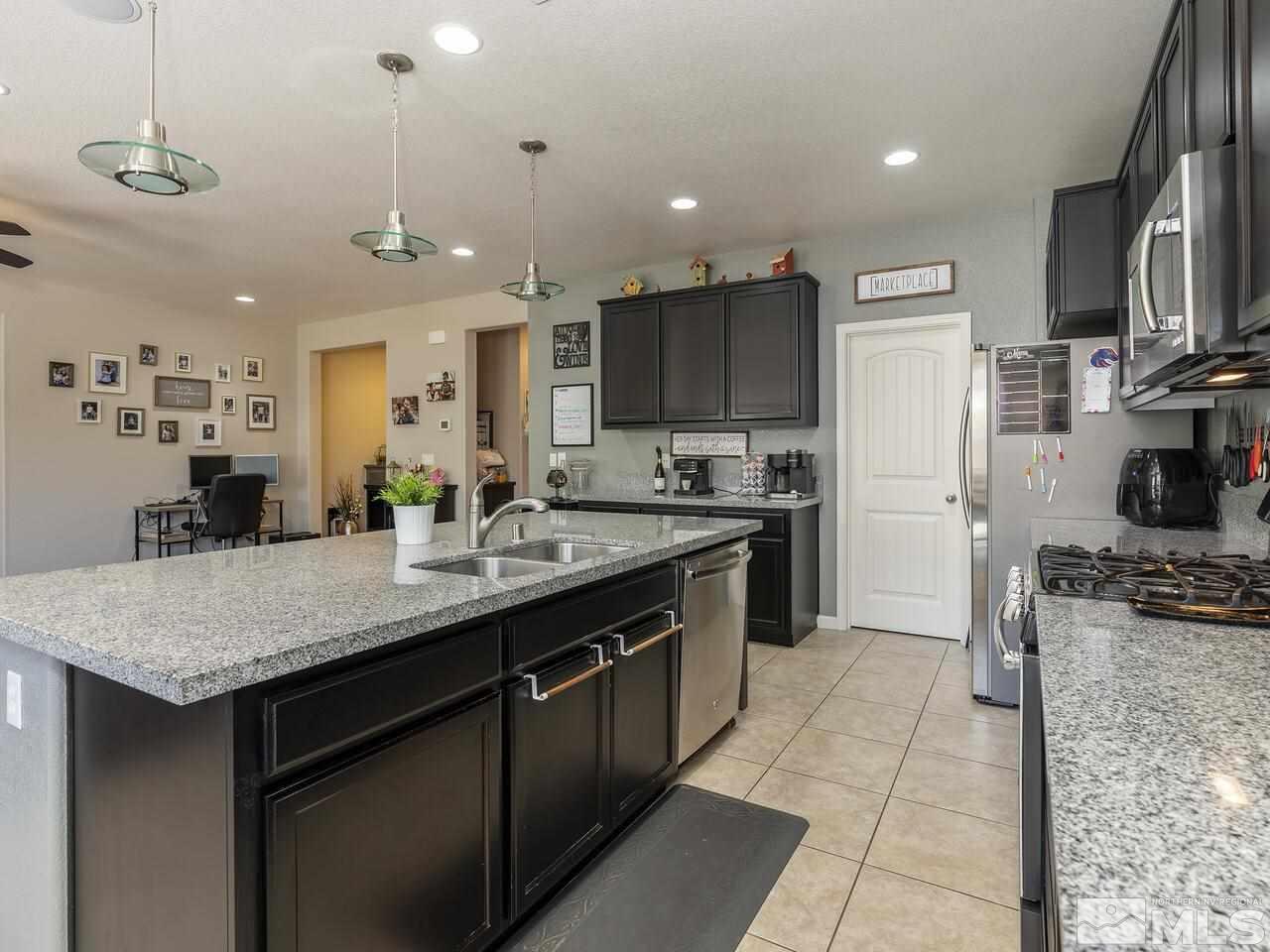 2090 Tawleed Road Reno, NV 89521 - Photo 10 of 24 a kitchen with stainless steel appliances granite countertop a sink a stove and a refrigerator