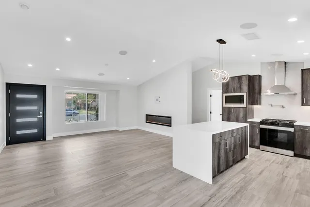 a large kitchen with stainless steel appliances granite countertop a stove a sink and a refrigerator