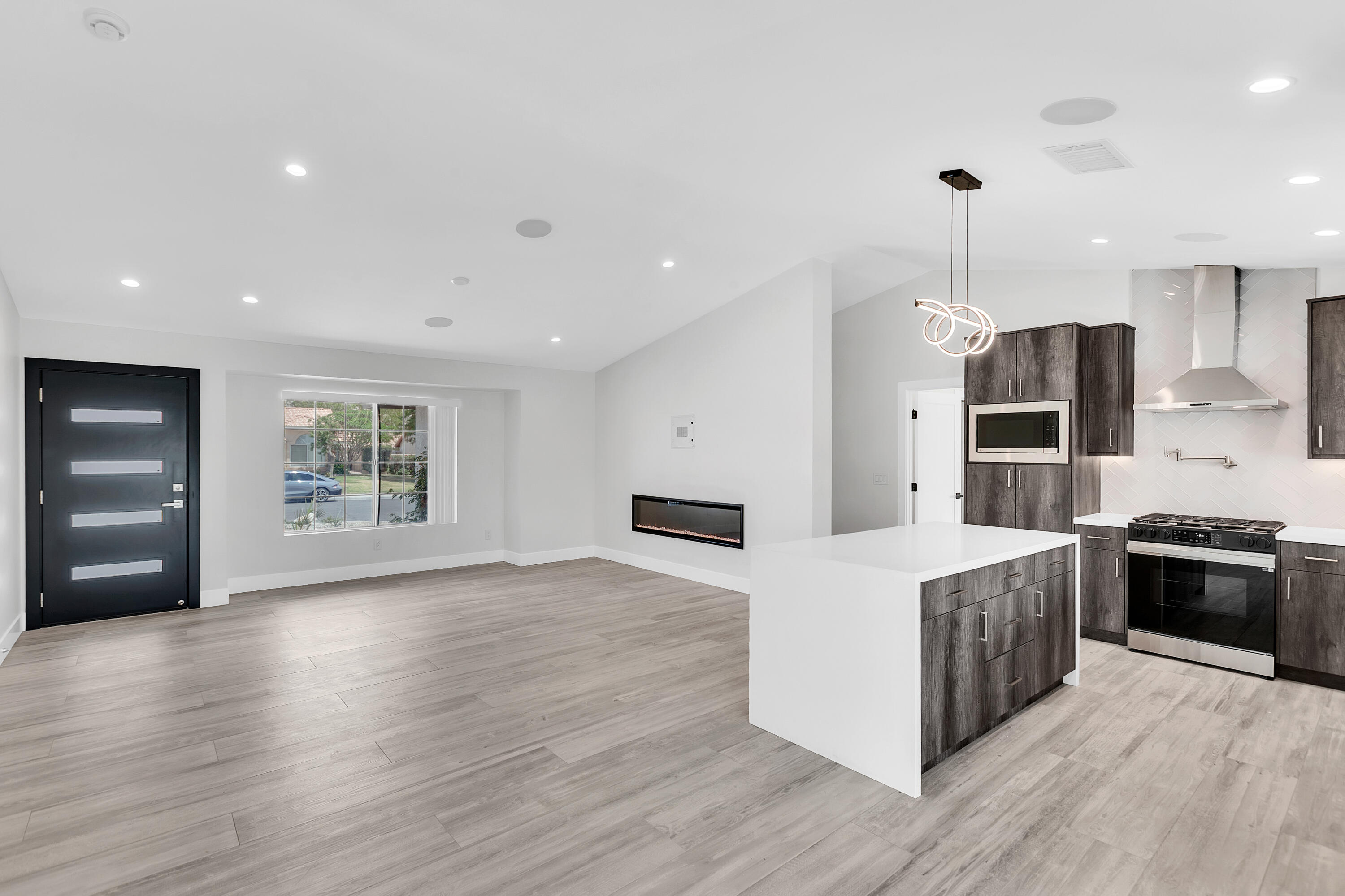 a large kitchen with stainless steel appliances granite countertop a stove a sink and a refrigerator