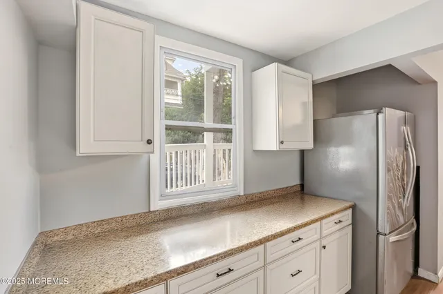 a kitchen with granite countertop a sink a stove and cabinets