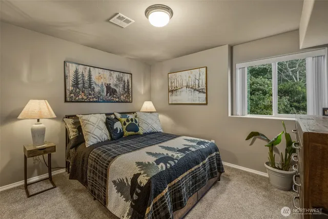 a bedroom with a bed and a painting on the wall