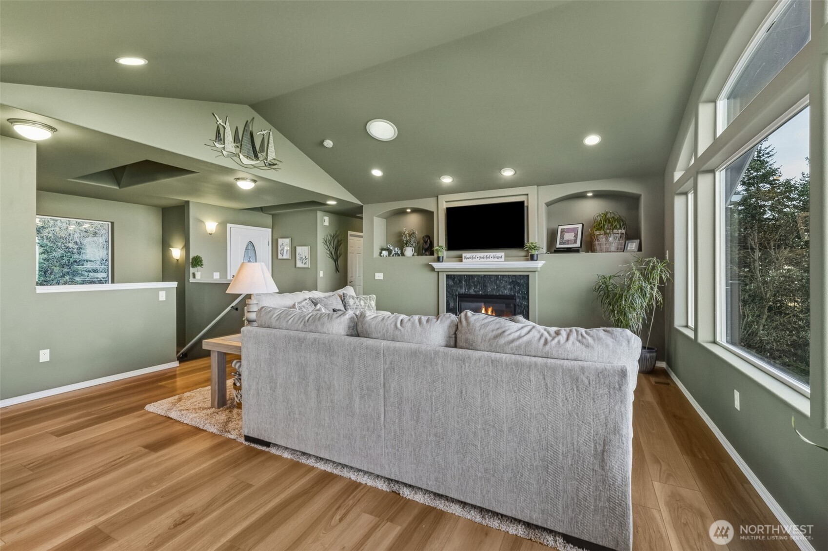 855 Louella Heights Road Sequim, WA 98382 - Photo 32 of 40 a living room with furniture a fireplace and a flat screen tv