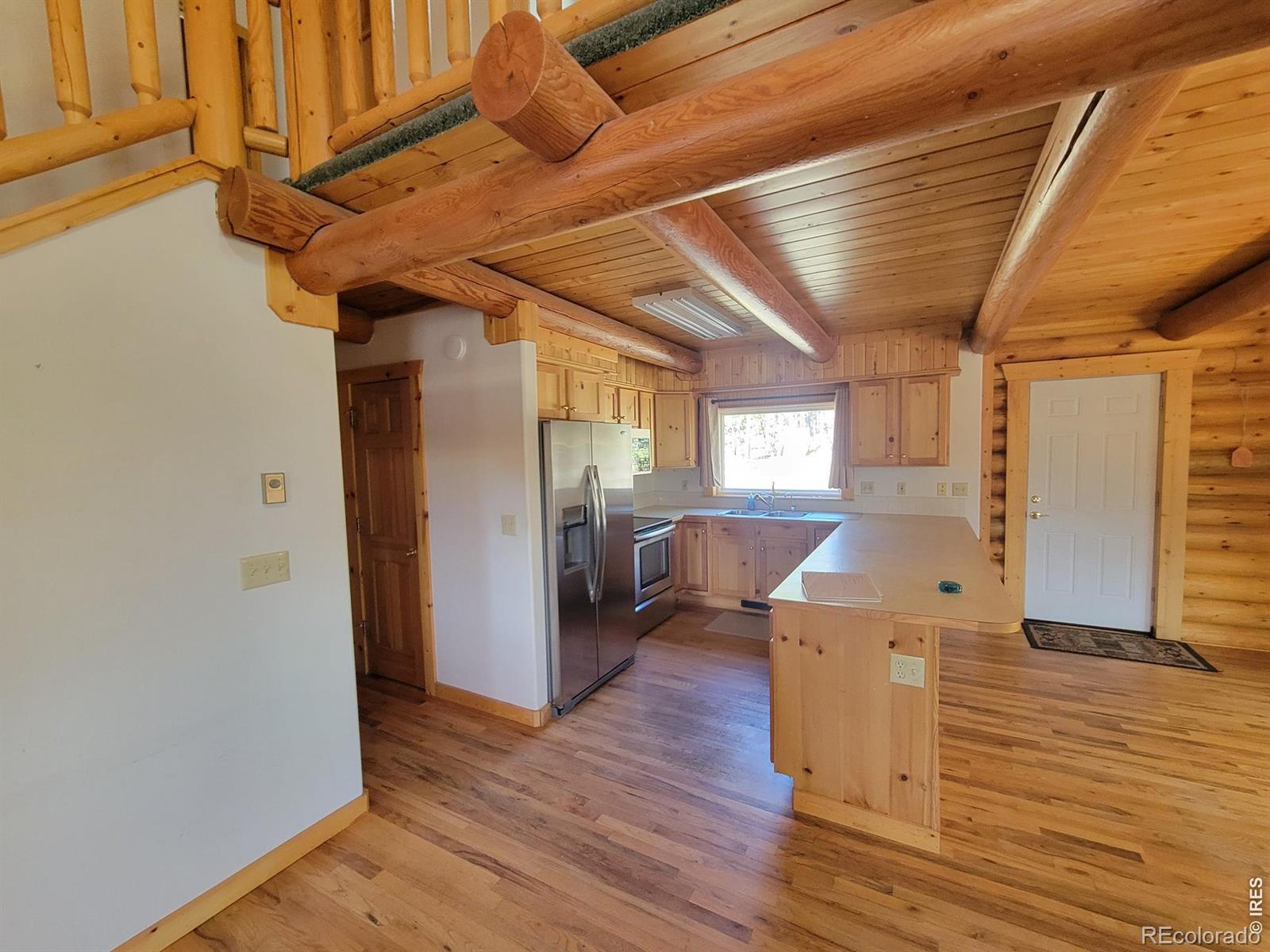 2225 North County Road Red Feather Lakes, CO 80545 - Photo 13 of 21 a view of a hallway with wooden floor and staircase