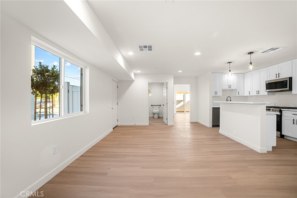 306 West Congress Street Colton, CA 92324 - Photo 3 of 28 a view of an empty room and kitchen with wooden floor