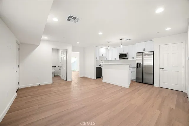 a view of a kitchen with a refrigerator and a microwave