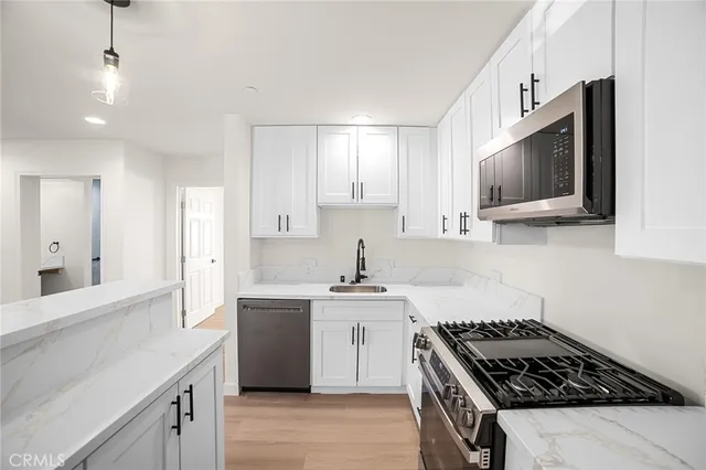 a kitchen with stainless steel appliances a sink stove and cabinets