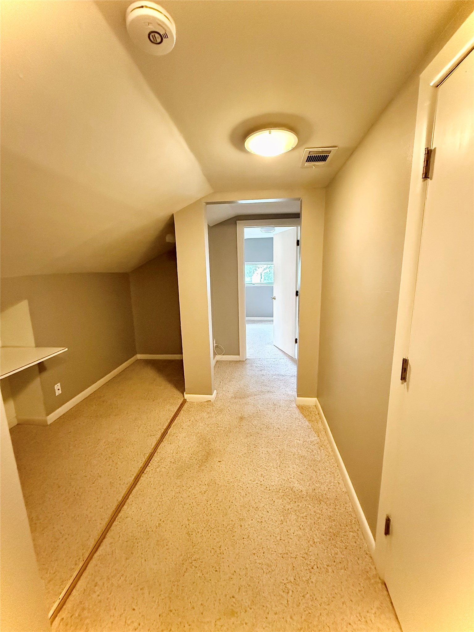 423 South Main Street Lockhart, TX 78644 - Photo 15 of 26 Carpeted room featuring a built-in desk, sloped ceilings, and neutral wall paint