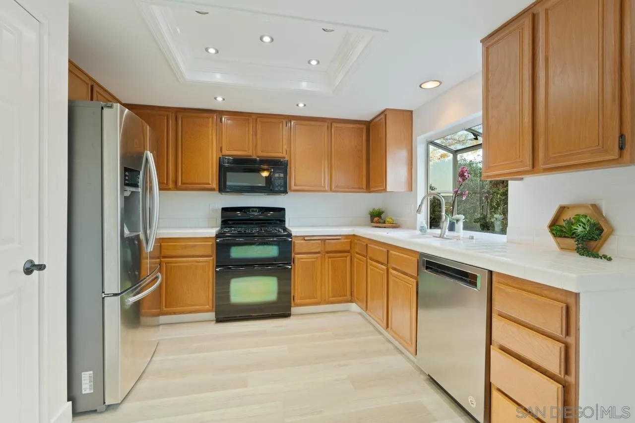 1904 Willow Ridge Drive Vista, CA 92081 - Photo 28 of 70 a kitchen with stainless steel appliances granite countertop a stove a sink and a refrigerator