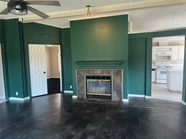 an empty room with wooden floor and a fireplace
