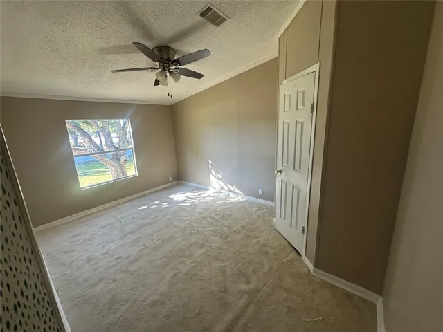 an empty room with windows and fan