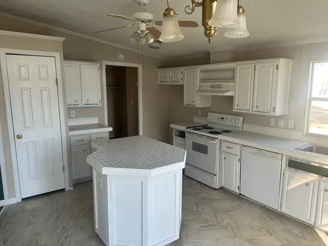 a kitchen with cabinets appliances and a window