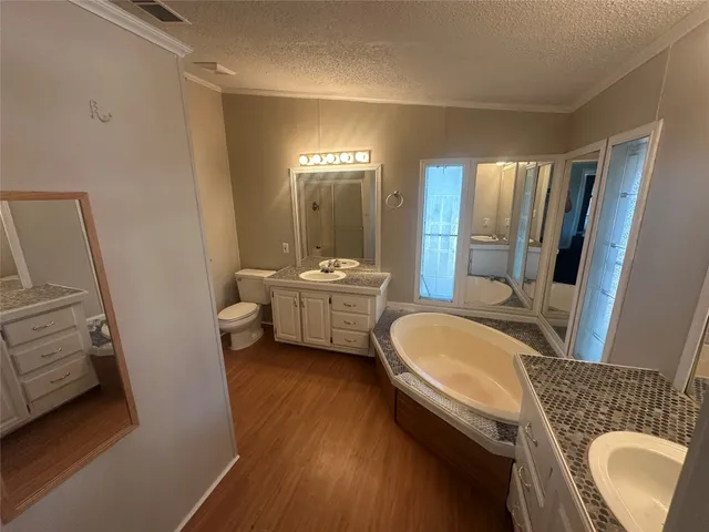 a en suite bathroom with a double vanity sink a mirror and a bathtub