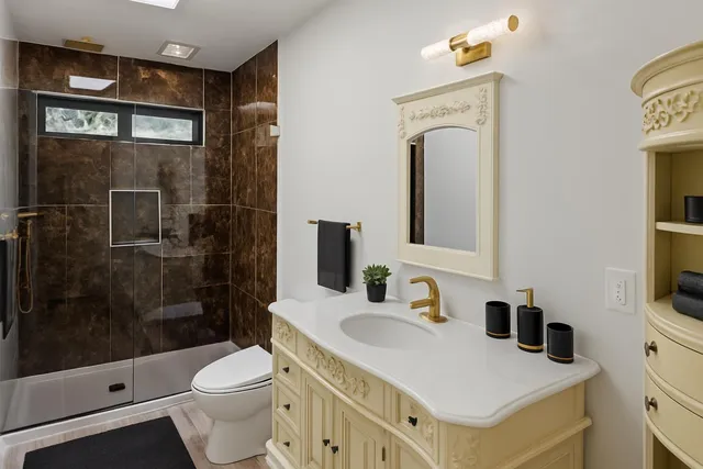 a bathroom with a sink a toilet and shower