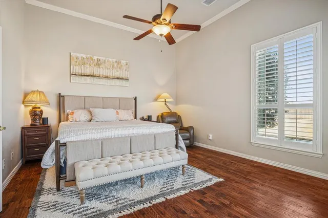 a bedroom with a bed wooden floor and window