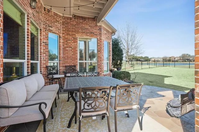 a view of a patio with a table chairs and a swimming pool