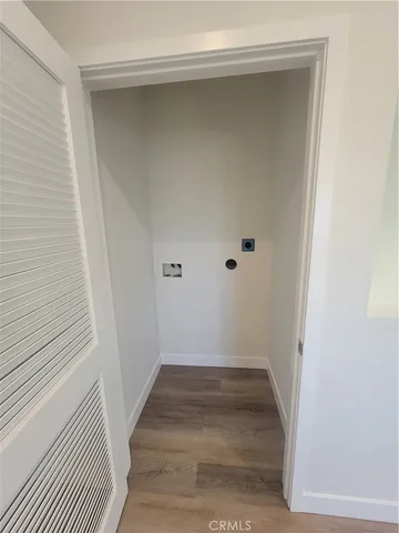 an empty room with wooden floor and window