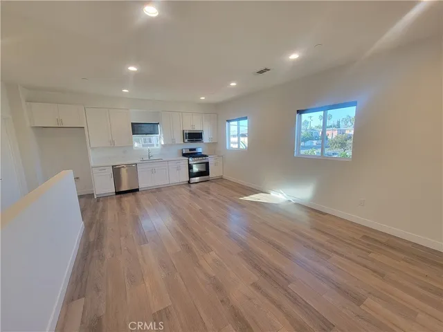 a view of an empty room with wooden floor
