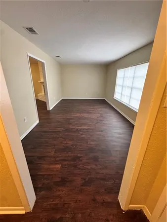 a view of empty room with window and wooden floor