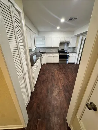 a view of a kitchen with wooden floor and electronic appliances