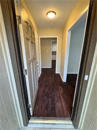 a view of a hallway with wooden floor and stairs