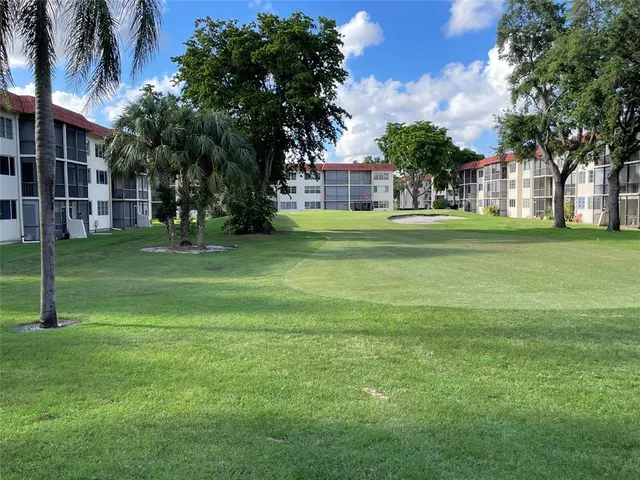 a kitchen with stainless steel appliances granite countertop a refrigerator a sink and white cabinets