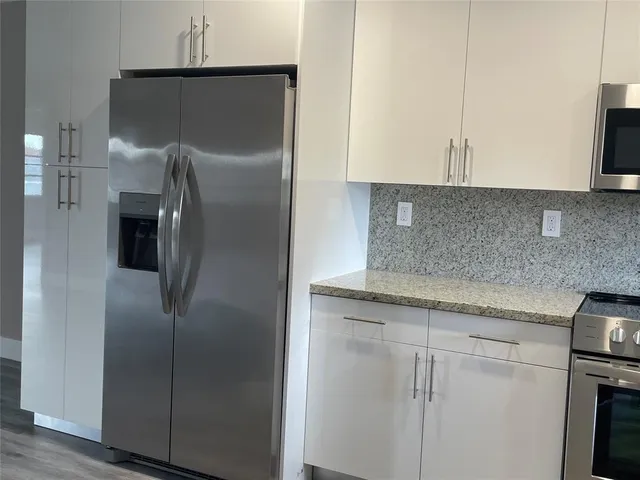 a view of a room with wooden floor and a window