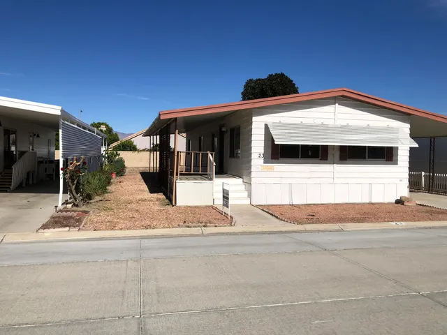 a view of a house with a tree and wooden fence