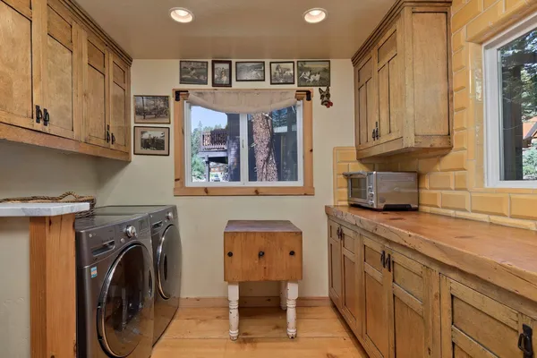 a utility room with stainless steel appliances lots of furniture and cabinets