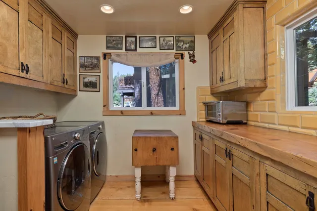 a utility room with stainless steel appliances lots of furniture and cabinets
