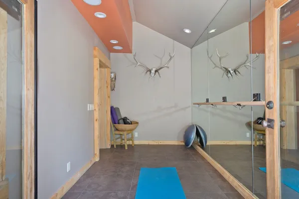 a view of a room with gym equipment and a rug
