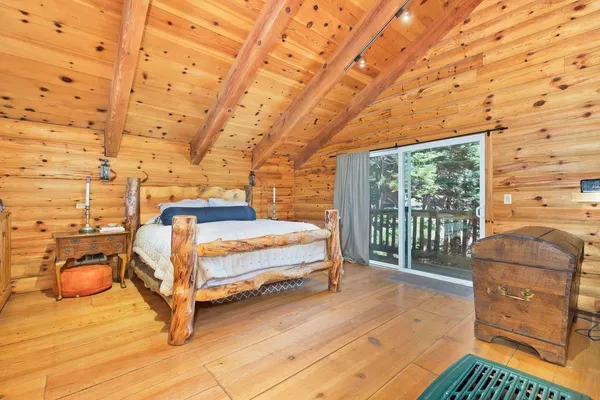 a spacious bedroom with a bed and a flat tv screen