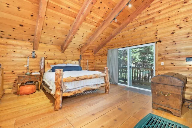 a spacious bedroom with a bed and a flat tv screen